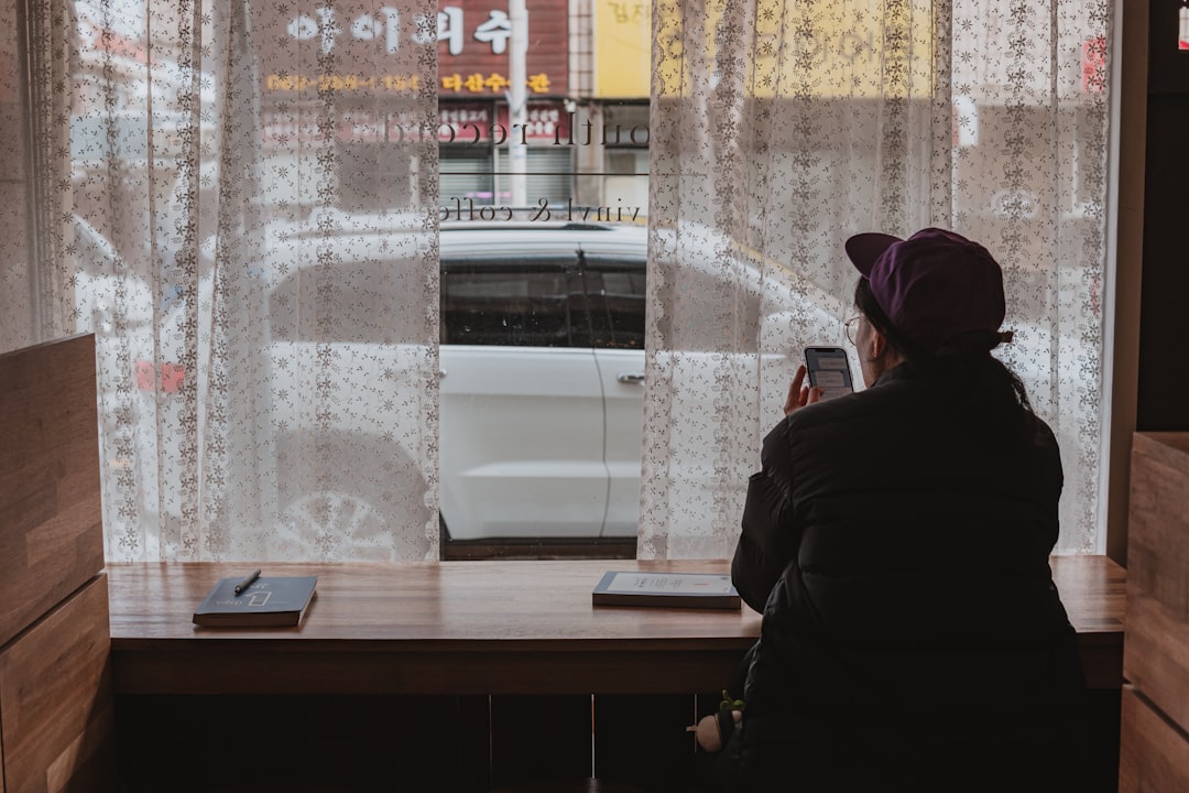 안도하는 표정의 소상공인이 서류를 들고 있는 모습. 배경에는 작은 상점이나 카페가 흐릿하게 보이며, 소상공인 정책자금 지원을 나타냅니다. 블루-그레이 톤.